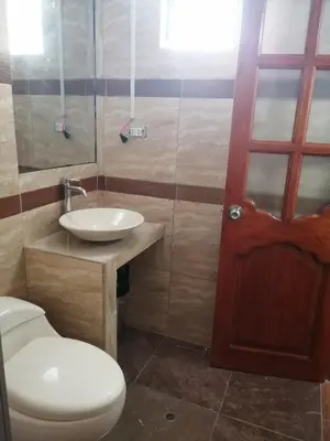 a bathroom with a toilet and a sink and a door at Casa ValPer in Cusco