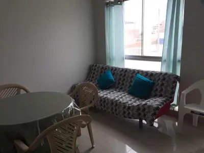 a living room with a couch with blue pillows and a table at DEPARTAMENTO SAN BARTOLO-2dormitorios in Lima