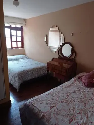 a bedroom with two beds and a mirror and a table at Garden House Miraflores in Lima