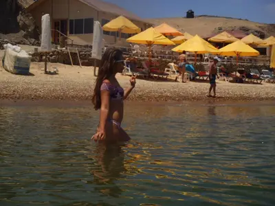 a young girl standing in the water at the beach at Paracas Penthouse first line Boardwalk in Paracas