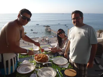a group of people standing around a table with food at Paracas Penthouse first line Boardwalk in Paracas
