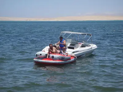 two people sitting on a boat in the water at Paracas Penthouse first line Boardwalk in Paracas