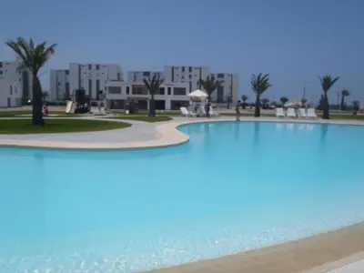 a large swimming pool in front of a building at Paracas Penthouse first line Boardwalk in Paracas