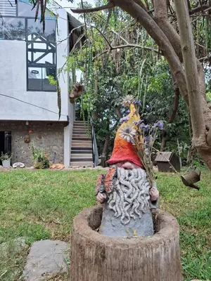 a statue of a person sitting in a tree stump at Cabañas o habitación en Fundo Huabayor in Lima