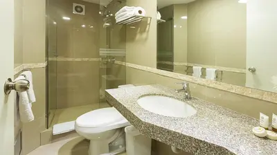 a bathroom with a sink and a toilet and a mirror at Howard Johnson by Wyndham Lima Miraflores Art House in Lima