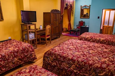 a hotel room with two beds and a flat screen tv at Hotel Marqueses in Cusco