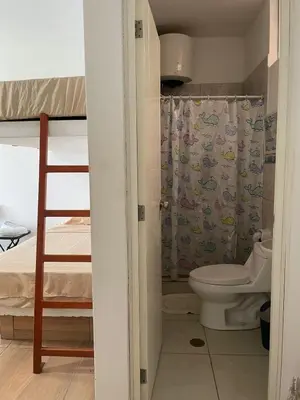a bathroom with a toilet and a bunk bed at Olas inn in Asia
