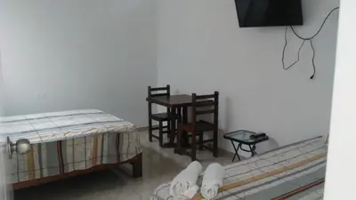 a room with a bed and a table and chairs at Olas inn in Asia