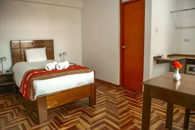 a bedroom with a bed with two towels on it at Hotel Del Prado Hometown in Cusco