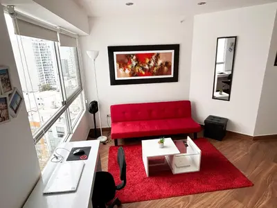 a living room with a red couch and a red rug at Apartamento moderno con vistas, WiFi gratis y cocina equipada in Lima