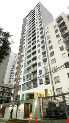 a person riding a skateboard in front of a tall building at Apartamento moderno con vistas, WiFi gratis y cocina equipada in Lima