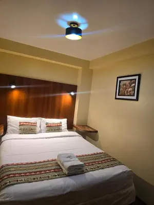 a bedroom with a bed and a ceiling fan at Marvelous Plaza in Cusco
