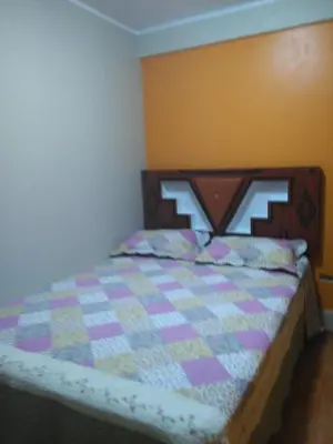 a bedroom with a bed with a quilt on it at PYMABET in Huancavelica
