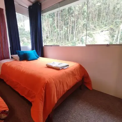 a bedroom with a bed and a large window at CASA SAPANTIANA, cerca a Sacsayhuaman in Cusco