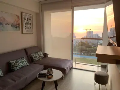 a living room with a couch and a large window at Connect in Lima