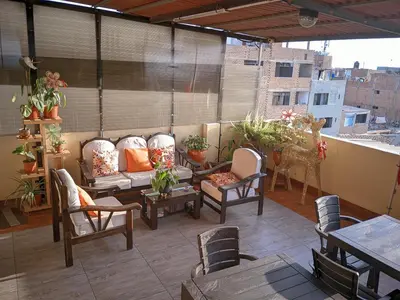 a patio with chairs and tables on a balcony at Peruvian Wasi - Bed & Breakfast in Lima