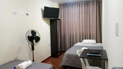 a hotel room with two beds and a desk at Peruvian Wasi - Bed & Breakfast in Lima