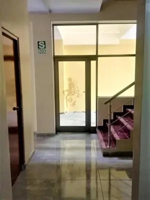 a hallway with a glass door and stairs in a building at Hotel ARKONA in Huancayo