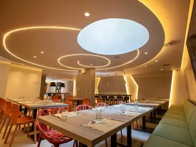 a dining room with long tables and chairs at ibis Styles Lima Benavides Miraflores in Lima
