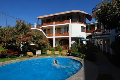 a person swimming in a pool in front of a building at Hotel Alegria Nasca in Nazca