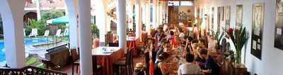 a group of people sitting at tables in a restaurant at Hotel Alegria Nasca in Nazca