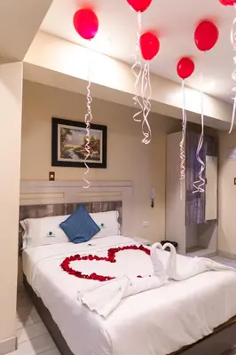 a bed with red balloons hanging from the ceiling at Hotel Konford Cañete in Imperial