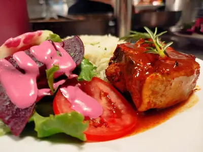 a plate of food with meat and tomatoes and rice at Hotel Konford Cañete in Imperial
