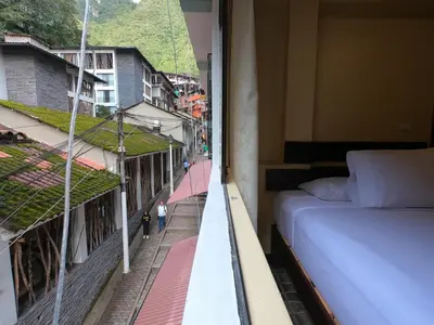 a bedroom with a bed and a view of a street at Don Feli House in Machu Picchu
