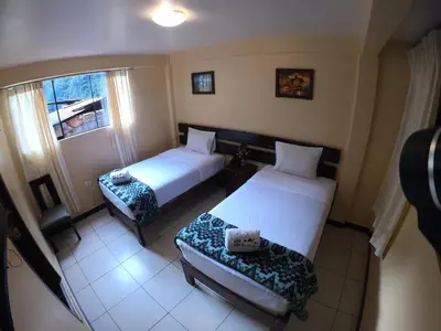 a hotel room with two beds and a window at Don Feli House in Machu Picchu