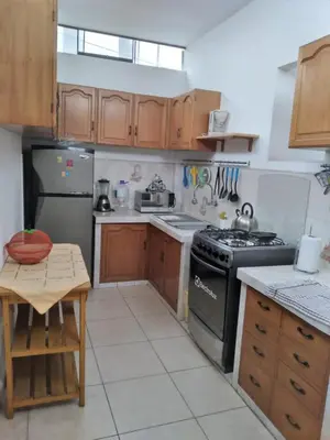 a kitchen with wooden cabinets and a stove top oven at CASA BONITA in Lima