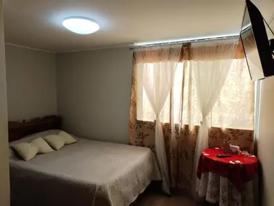 a bedroom with a bed and a window with curtains at CASA BONITA in Lima