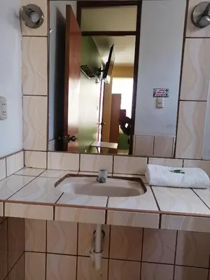 a bathroom sink with a large mirror above it at Hostal Boulevard in Nazca