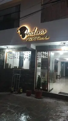 a restaurant with a neon sign on the side of a building at ANDINO HOTEL MACHUPICCHu in Machu Picchu