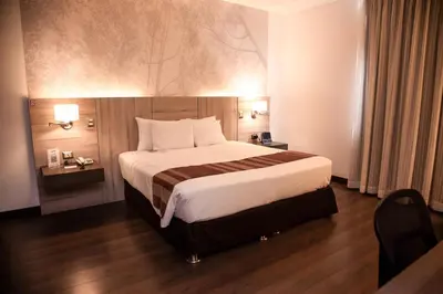 a bedroom with a large bed in a hotel room at Aku Hotels in Lima