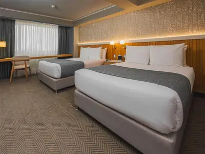 a hotel room with two beds and a chair at Sonesta Hotel Miraflores in Lima