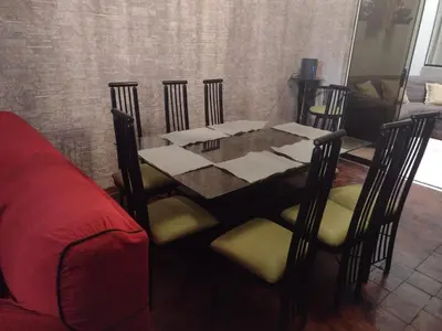 a dining room table with chairs and a red couch at Inka Ayllu Hospedaje in Lima