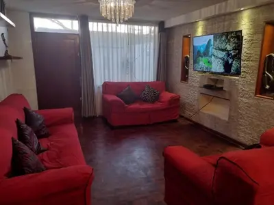 a living room with two red couches and a tv at Inka Ayllu Hospedaje in Lima