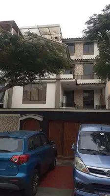 two cars parked in a parking lot in front of a building at Inka Ayllu Hospedaje in Lima