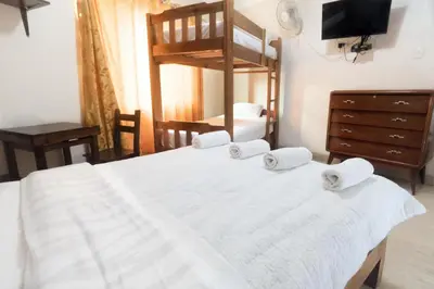 a bedroom with a white bed with a bunk bed at Hostal Sueños Breña in Lima