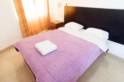 a bedroom with a purple bed with two towels on it at Hostal Sueños Breña in Lima