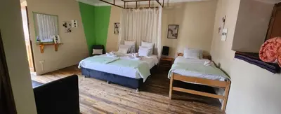 a bedroom with two beds and green walls at Loki Cusco in Cusco