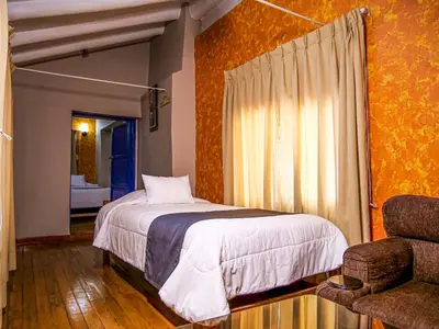 a bedroom with a bed and a chair at LO NUESTRO House in Cusco