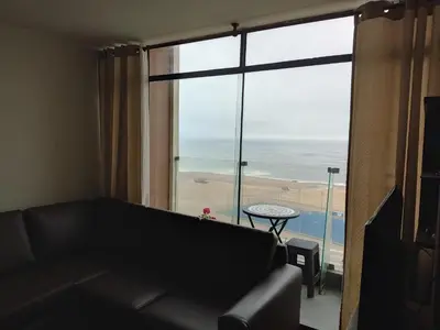 a living room with a couch and a large window at Arena Costa Lima private rooms Peru in Lima