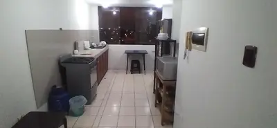 a small kitchen with a stove and a refrigerator at Arena Costa Lima private rooms Peru in Lima