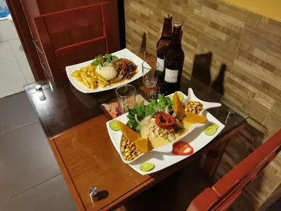 a table with two plates of food and two bottles of wine at Hotel Dia y Noche in Lima