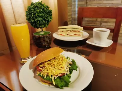 a table with two plates of food and a sandwich at Hotel Dia y Noche in Lima