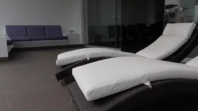 two white beds in a room with a couch at Donde Lalo in Asia