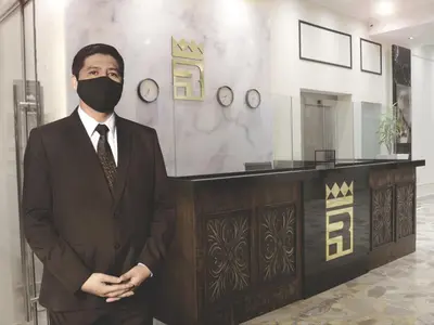 a man in a suit wearing a mask at Real Hotel in Huánuco