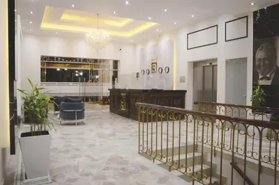 a lobby of a building with a staircase and a chandelier at Real Hotel in Huánuco