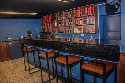 a bar with four stools in a room at Real Hotel in Huánuco